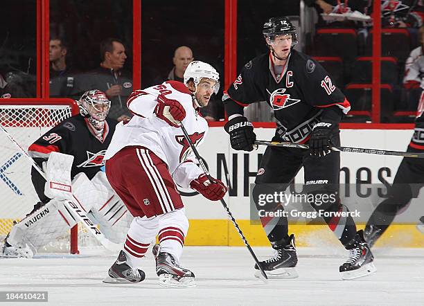 Eric Staal of the Carolina Hurricanes and Antoine Vermette of the Phoenix Coyotes keep their eyes on the puck during their NHL game at PNC Arena on...