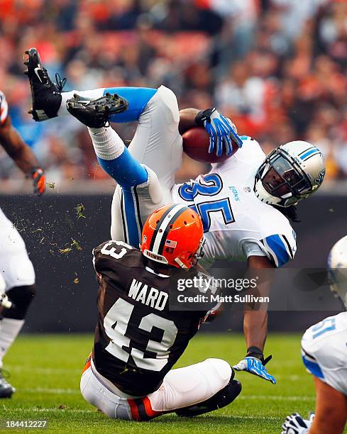 Running back Joique Bell of the Detroit Lions is tackled by defensive back T.J. Ward of the Cleveland Browns at FirstEnergy Stadium on October 13,...
