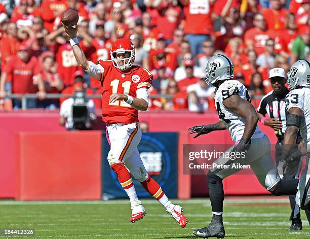 Quarterback Alex Smith of the Kansas City Chiefs throws a pass down field under pressure from linebacker Kevin Burnett of the Oakland Raiders during...