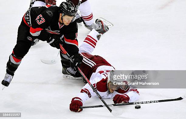Antoine Vermette of the Phoenix Coyotes dives to knock the puck away from Jeff Skinner of the Carolina Hurricanes during play at PNC Arena on October...