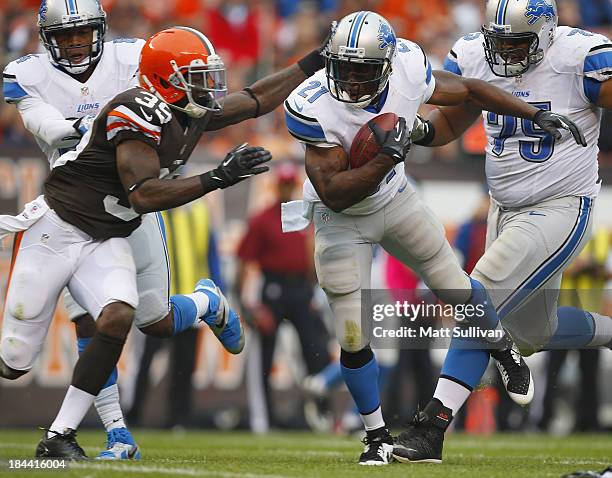 Running back Reggie Bush of the Detroit Lions scores a touchdown as his is hit by defensive back Tashaun Gipson of the Cleveland Browns at...