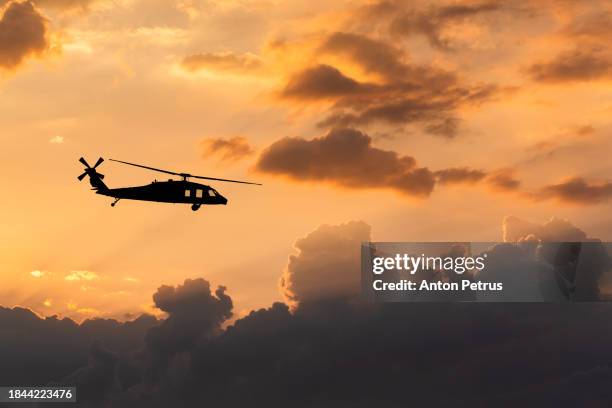 utility military helicopter  on the background of the sunset sky - attack helicopter stock pictures, royalty-free photos & images
