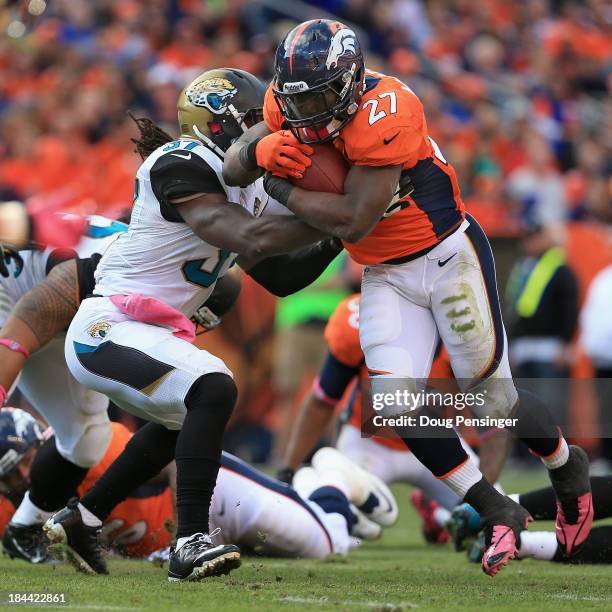 Running back Knowshon Moreno of the Denver Broncos breaks the tackle of strong safety John Cyprien of the Jacksonville Jaguars and rushes eight yards...