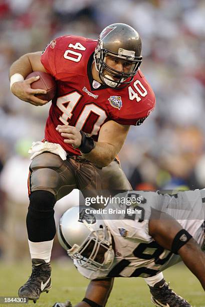 Mike Alstott of the Tampa Bay Buccaneers runs around Napoleon Harris of the Oakland Raiders in Super Bowl XXXVII on January 26, 2003 at Qualcomm...