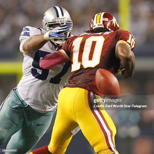 Dallas Cowboys linebacker DeVonte Holloman knocks the ball from Washington Redskins quarterback Robert Griffin III at AT&T Stadium in Arlington,...