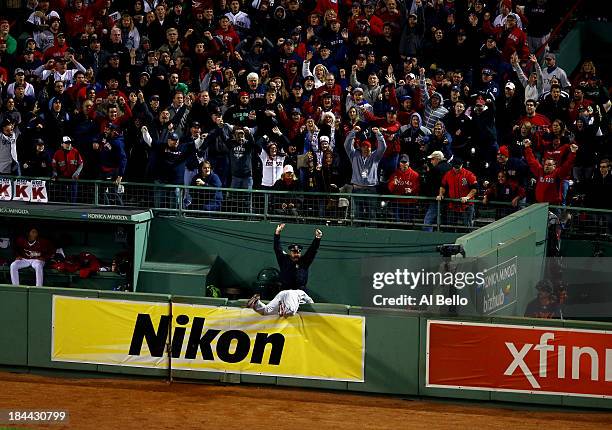 Torii Hunter of the Detroit Tigers falls over the bullpen fence after trying to catch a grand slam hit by David Ortiz of the Boston Red Sox as Boston...