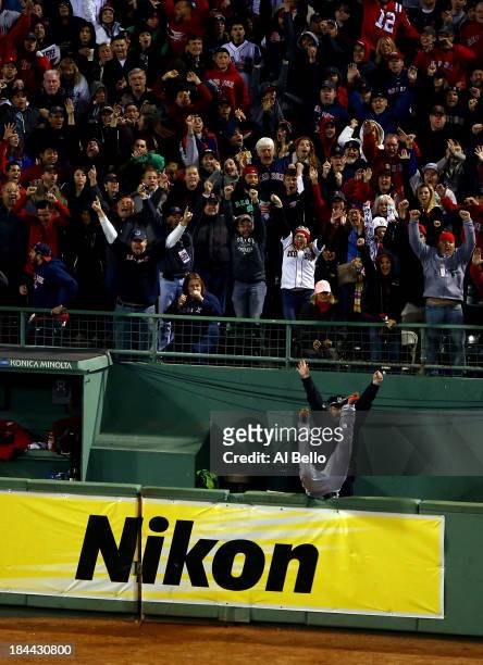 Torii Hunter of the Detroit Tigers falls over the bullpen fence after trying to catch a grand slam hit by David Ortiz of the Boston Red Sox as Boston...