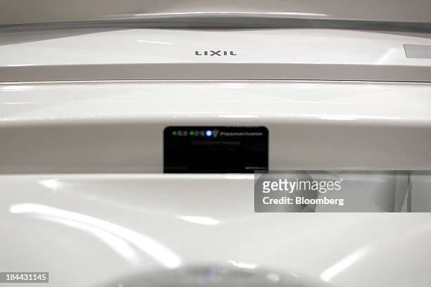 The Lixil Group Corp. Logo is displayed on a Satis toilet displayed at the company's showroom in Tokyo, Japan, on Friday, Oct. 11, 2013. Lixil and...