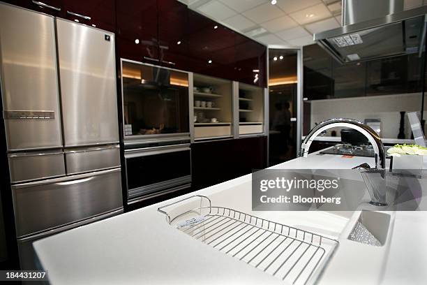 Lixil Group Corp. Kitchen unit stands on display at the company's showroom in Tokyo, Japan, on Friday, Oct. 11, 2013. Lixil and Development Bank of...