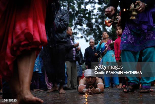 Nepalese Hindu devotees offer prayers by rolling on the ground after performing a bathing ritual at the biggest Hindu festival, Dashain , in...