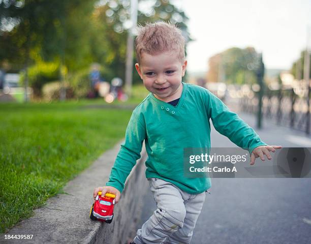 baby boy playing with toy car - toddler boy fotografías e imágenes de stock