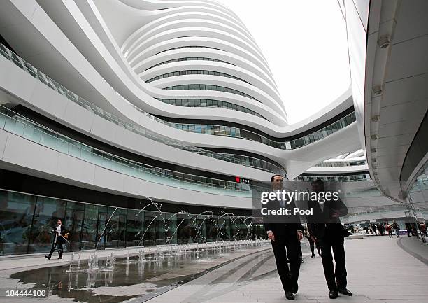 Satoshi Ohashi , Associate Director of Beijing Studio of Zaha Hadid Architects, guides Britain's Chancellor of the Exchequer George Osborne during...