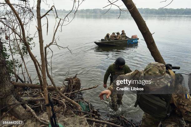 Ukrainian infantrymen soldiers travel on the Dnipro River on boats on September 14, 2023 in Kherson region, Ukraine. Ukrainian soldiers sail to their...