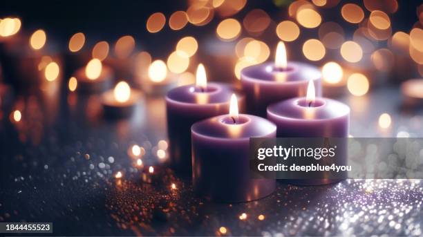 velas moradas con bokeh de fondo - adviento fotografías e imágenes de stock