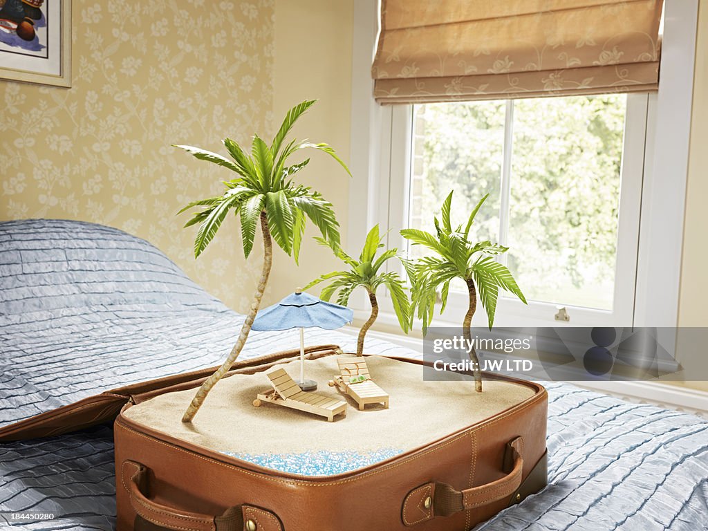 Tropical beach scene inside a suitcase