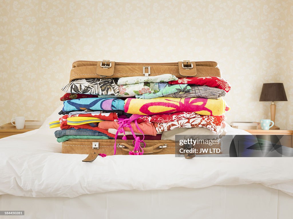 Overpacked suitcase on bed, suburban home