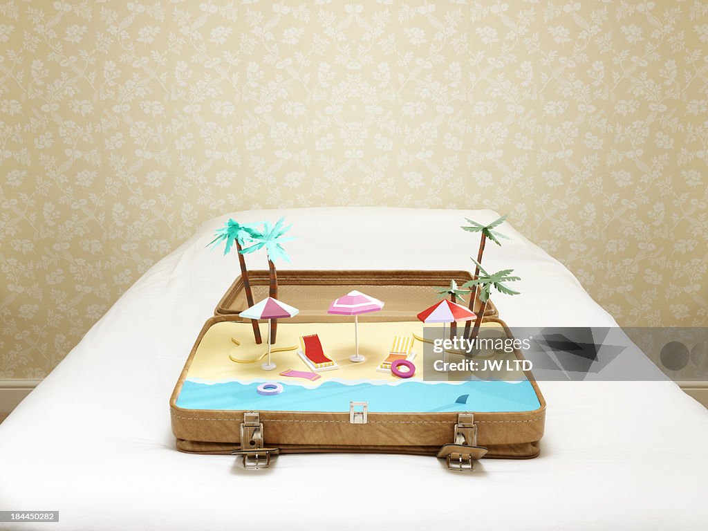 Tropical beach scene inside a suitcase