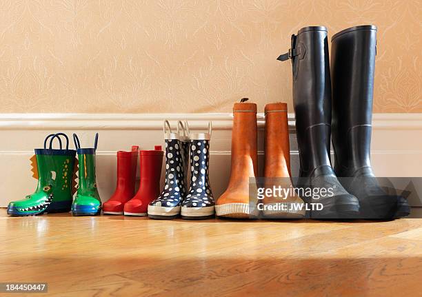 wellington boots in a row in hallway - stiefel stock-fotos und bilder