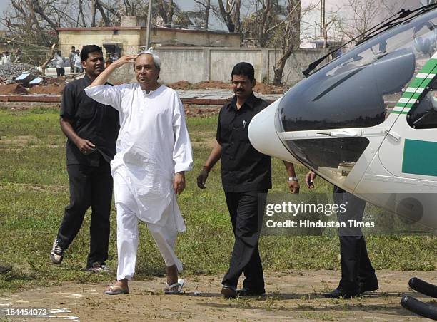 Odisha Chief Minister Naveen Patnaik coming out of chopper after aerial survey of the Phailin affected Ganjam district on October 14, 2013 in...