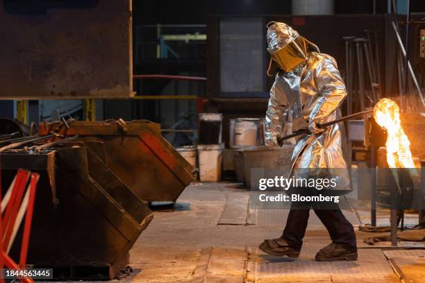 Worker removes a sample from a crucible of molten aluminum in the foundry at the Aluminum Dunkerque SAS smelter in Dunkirk, France, on Tuesday, Dec....