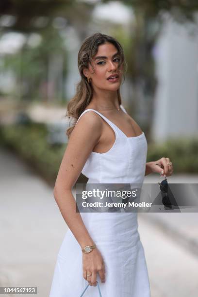 Jessica De Oliveira seen wearing gold earrings, Riani white strappy long dress, Jacquemus light blue suede leather Bambino Long bag, Dior gold...