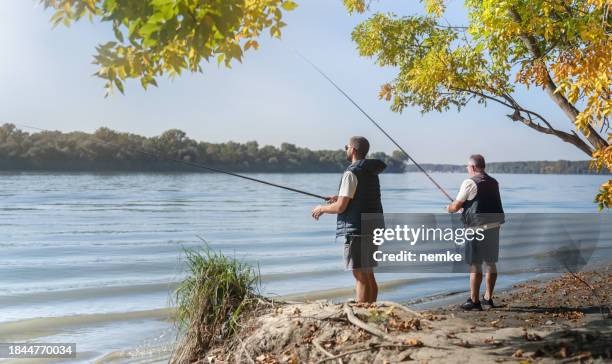 people standing and fishing in beautiful nature - catch of fish stock pictures, royalty-free photos & images