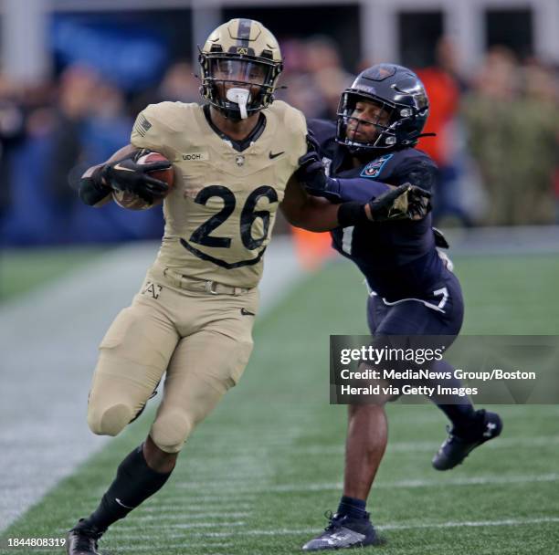 Foxboro, MA- Army Black Knights running back Kanye Udoh runs for long yards Navy Midshipmen defensive end Mbiti Williams Jr. Shoves him out as as...