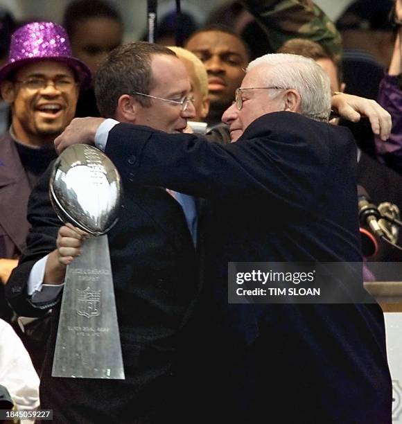 Baltimore Ravens owner Art Modell embraces his son and team President David on stage with the Vince Lombardi Trophy during a victory parade and...