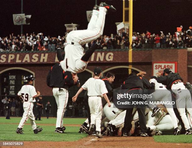 San Francisco Giants pile up in the field as Giants Armando Rios does a flip after defeating the Arizona Diamondbacks to clinch the National League...