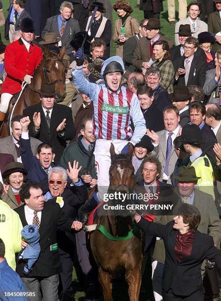 English Champion jockey Tony McCoy celebrates entering the winners' enclosure 15 March 2000, after winning the Queen Mother Champion Chase on Edredon...