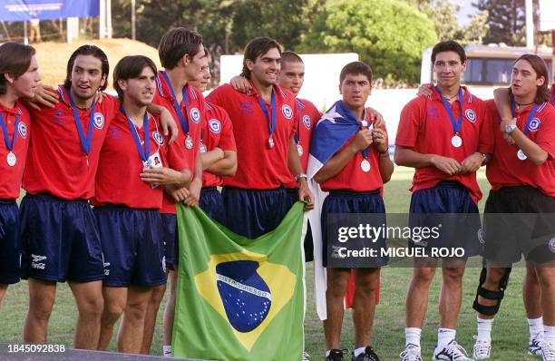 Members of soccer's team Chile pose with their medals and flag 06 February 2000 in Londrina. Brazil, after they qualified for the 2000 Olympics in...