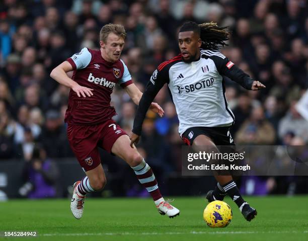 Alex Iwobi of Fulham FC and James Ward-Prowse of West Ham United during the Premier League match between Fulham FC and West Ham United at Craven...