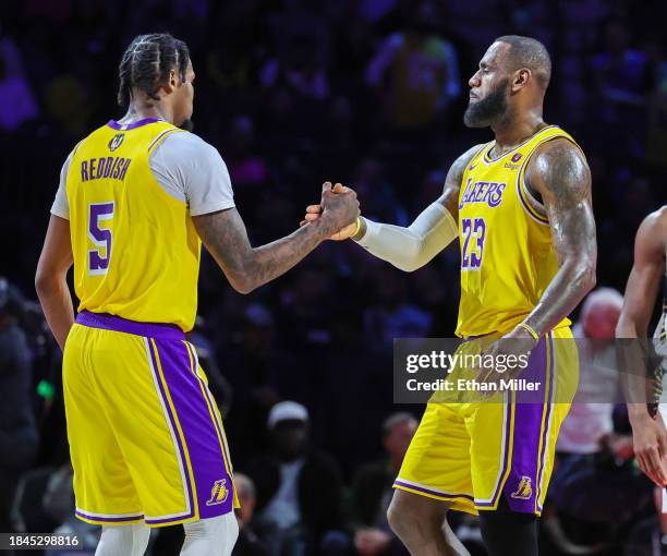 Cam Reddish and LeBron James of the Los Angeles Lakers shake hands as James checks out late in the fourth quarter of the championship game of the...