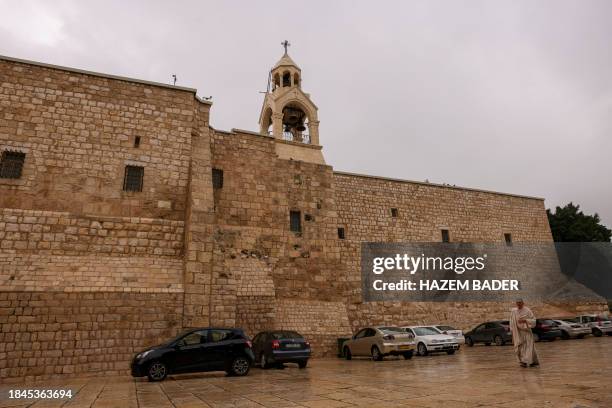 Pilgrim walks outside the Church of the Nativity in the occupied West Bank city of Bethlehem on December 13 less than two weeks before Christmas amid...