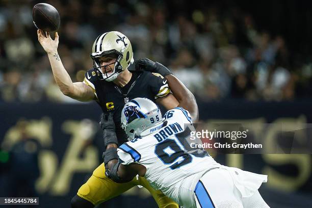 Derek Carr of the New Orleans Saints is tackled by Derrick Brown of the Carolina Panthers during the first quarter at Caesars Superdome on December...