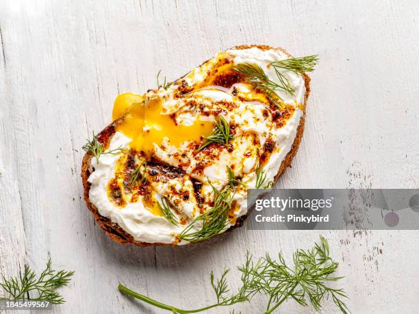 bocadillos caseros de huevos escalfados con queso crema y aceite de oliva. queso y huevos escalfados, sándwich con condimento. huevo escalfado con queso y aceite picante sobre tostadas. - bruschetta fotografías e imágenes de stock