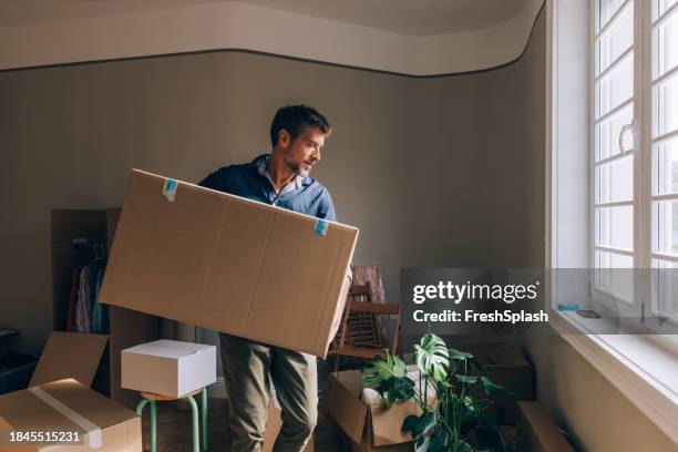 mudanza en solitario: hombre que lleva cajas - un solo hombre fotografías e imágenes de stock