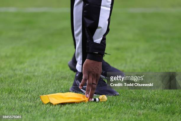 Referee picks up a flag during the second quarter between the Los Angeles Rams and Baltimore Ravens at M&T Bank Stadium on December 10, 2023 in...