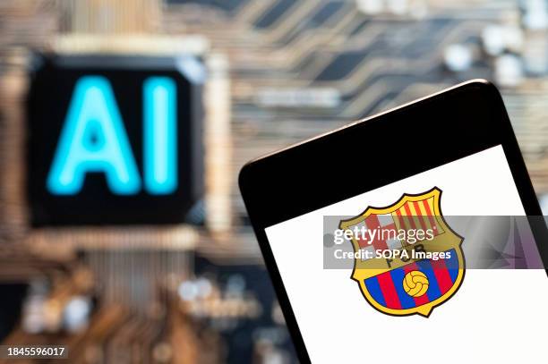 In this photo illustration, the Spanish professional LaLiga football team the Futbol Club Barcelona logo seen displayed on a smartphone with an...