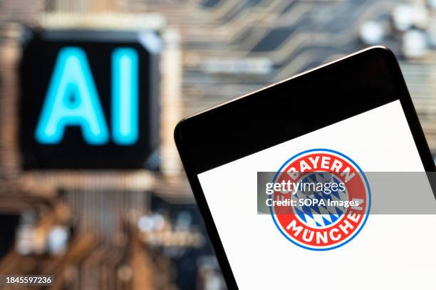 In this photo illustration, the German Bundesliga football club Bayern Munich team logo seen displayed on a smartphone with an Artificial...