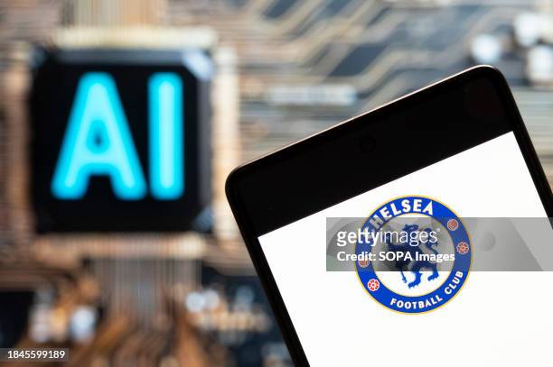 In this photo illustration, the English professional Premier League football club Chelsea team logo seen displayed on a smartphone with an Artificial...