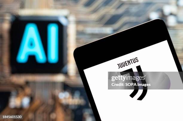 In this photo illustration, the Italian professional Serie A football club Juventus logo seen displayed on a smartphone with an Artificial...