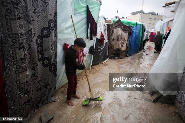 Palestinian boy is standing amidst the rain at a camp for displaced people in Deir El-Balah, in the central Gaza Strip, where many civilians are...