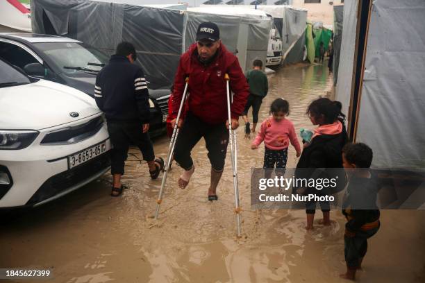 Palestinians are taking refuge amid the rain at a camp for displaced people in Deir El-Balah, in the central Gaza Strip, as battles continue between...