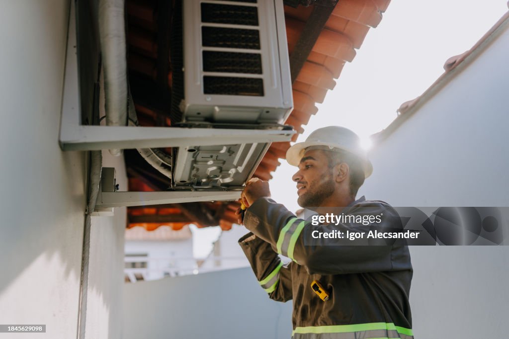 Technician checking air conditioning unit