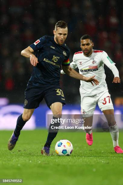 Silvan Widmer of FSV Mainz 05 challenges for the ball with Linton Maina of 1.FC Köln during the Bundesliga match between 1. FC Köln and 1. FSV Mainz...