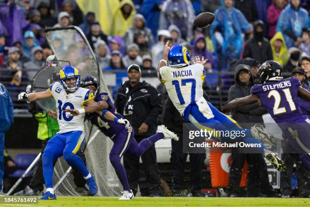 Puka Nacua of the Los Angeles Rams dives and completes a pass against Brandon Stephens of the Baltimore Ravens as Cooper Kupp of the Los Angeles Rams...