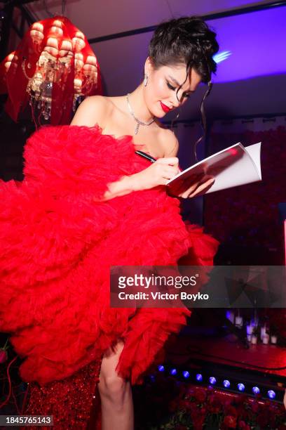 Angelina Usanova signs the "My home" book at the charity event hosted by Miss Universe Ukraine 2023 Angelina Usanova on December 10, 2023 in Nice,...