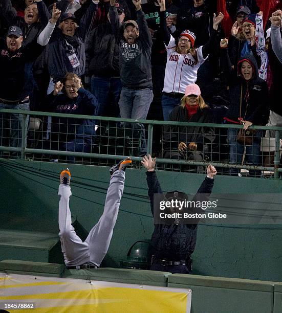 Detroit's Torii Hunter falls into the bullpen trying to catch Red Sox designated hitter David Ortiz's home run that tied the game in the eighth...