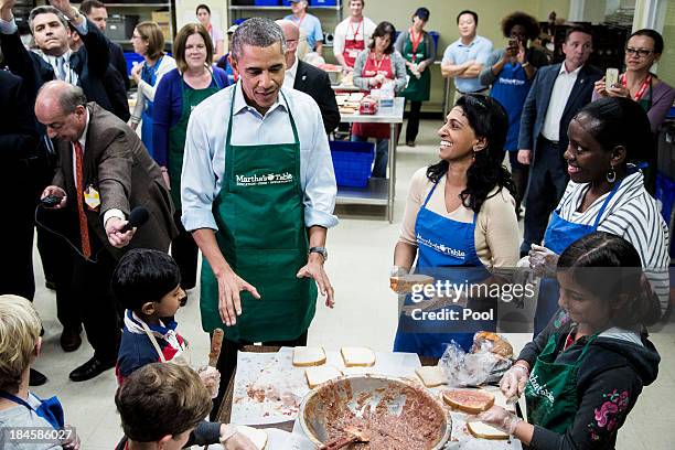 President Barack Obama visits visits with children on a day of service field trip at a Martha's Table kitchen on October 14, 2013 in Washington, D.C....